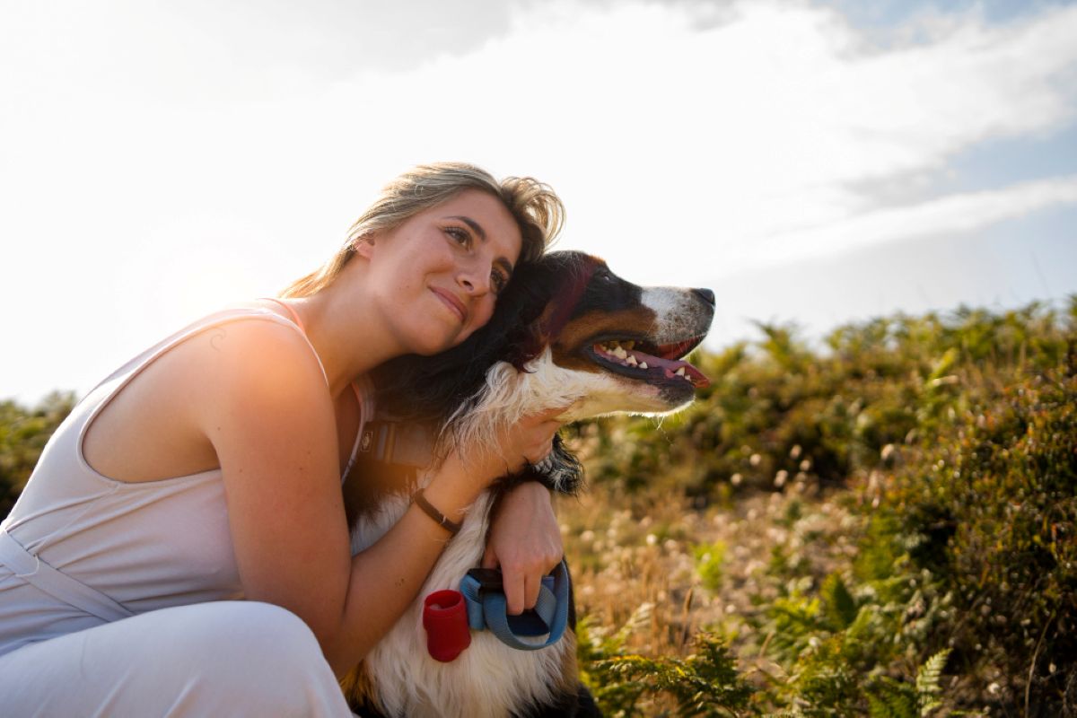 Persona abrazando a su perro en el campo