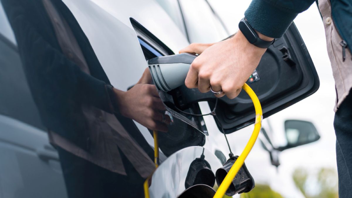 Persona cargando su coche electrico 
